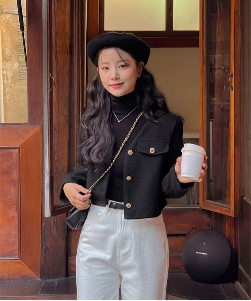 Woman wearing a black beret with a black turtleneck and white trousers