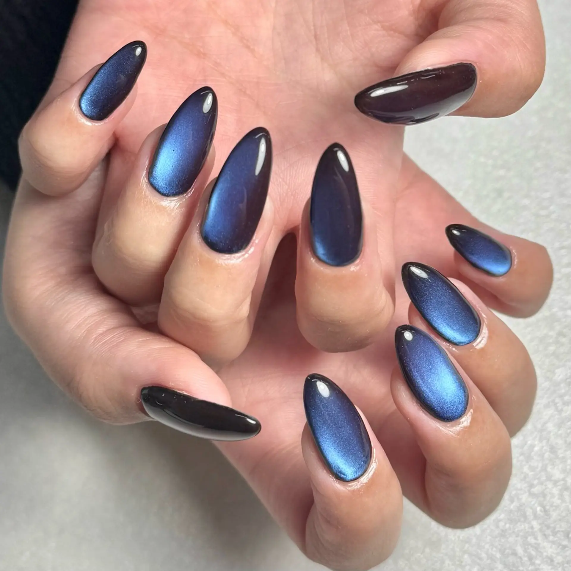 Long almond nails in midnight navy magnetic cat-eye polish with shifting shimmer