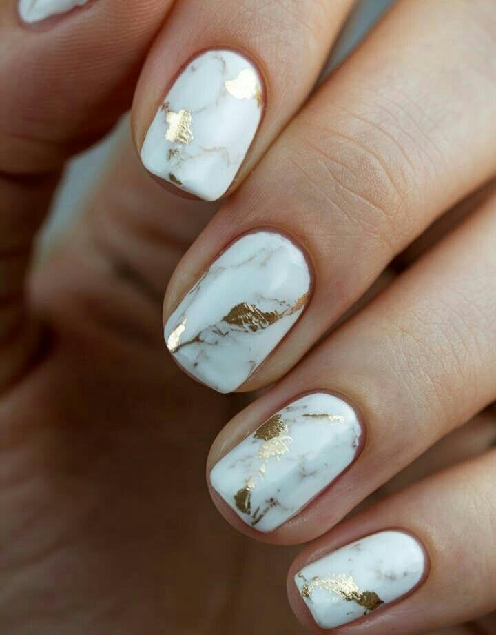 Short nails with white marble veining and gold foil accents