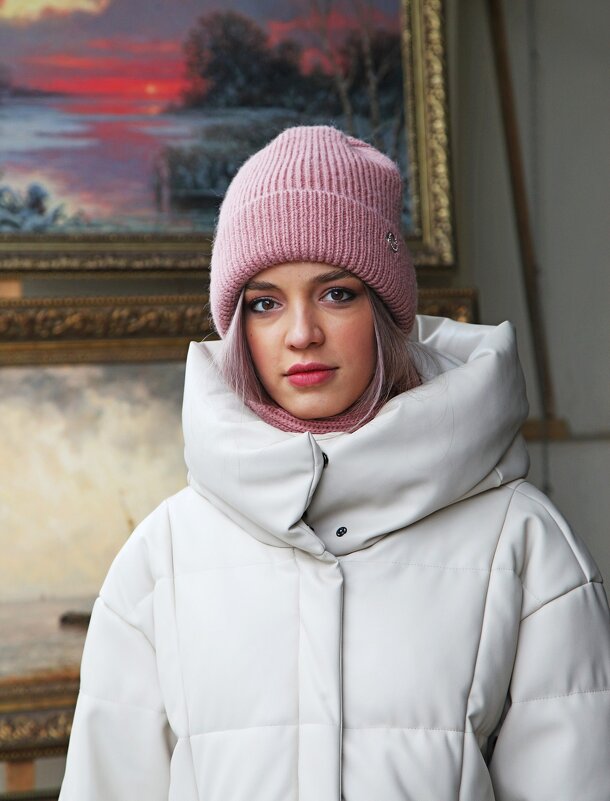 Woman in a pink ribbed beanie and oversized white puffer coat