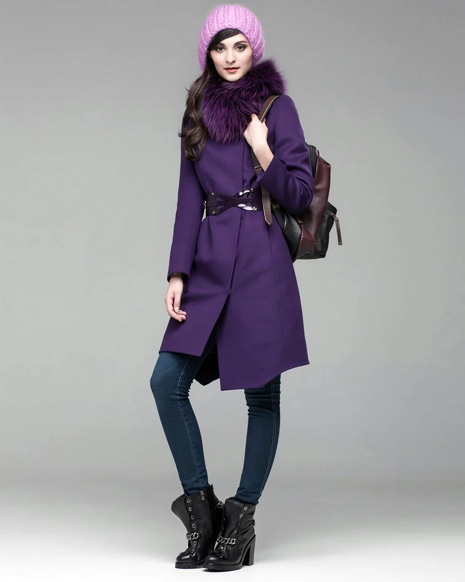Woman in a deep purple wool coat with fur collar, lilac knit beanie and black boots