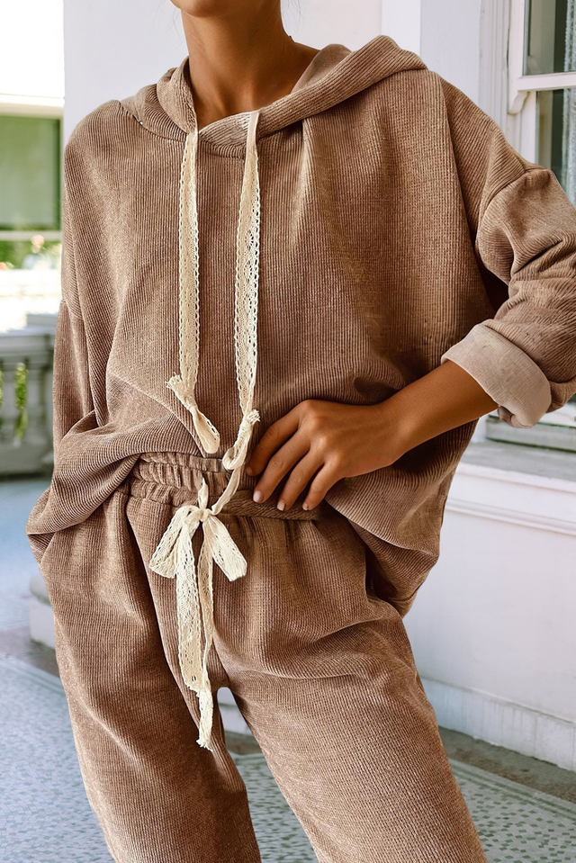 Woman wearing a tan corduroy hoodie and matching corduroy pants with lace drawstrings
