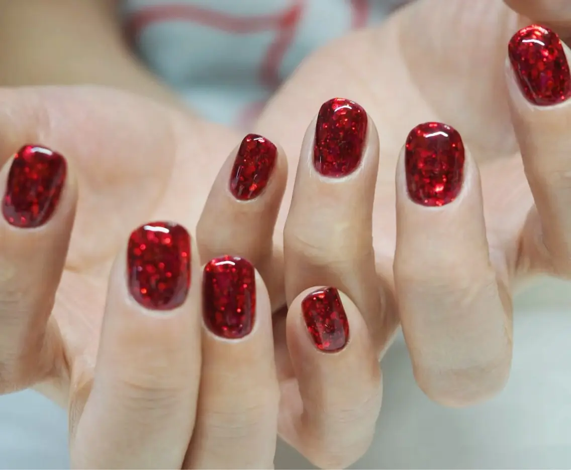 Short square nails in full sparkling red glitter.