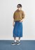 Woman in hoodie with denim midi skirt and sneakers