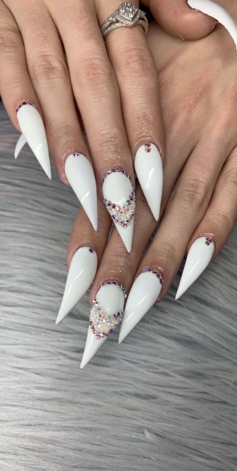Solid white stiletto nails decorated with rhinestones