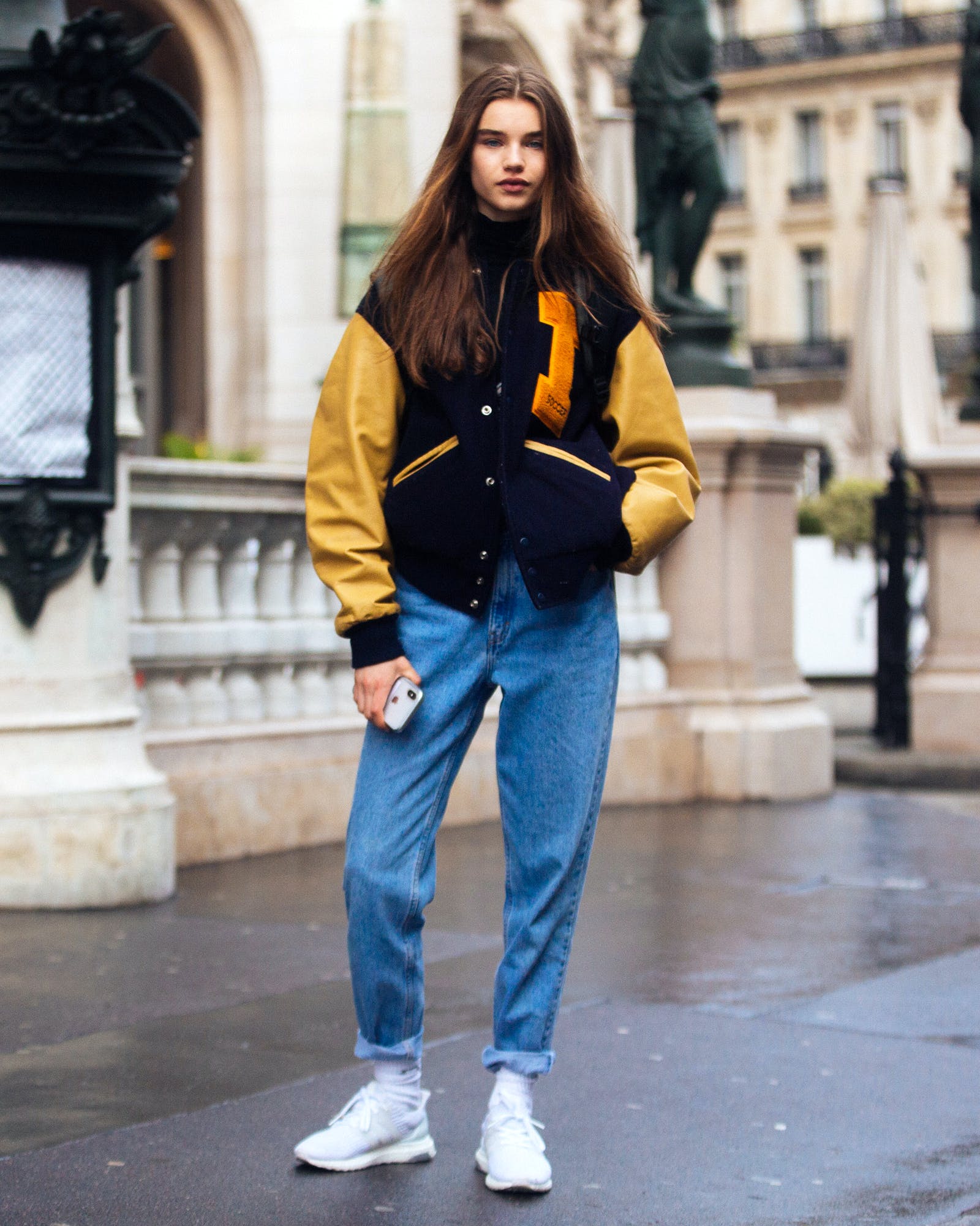 Woman wearing a varsity jacket with jeans in a sporty winter look