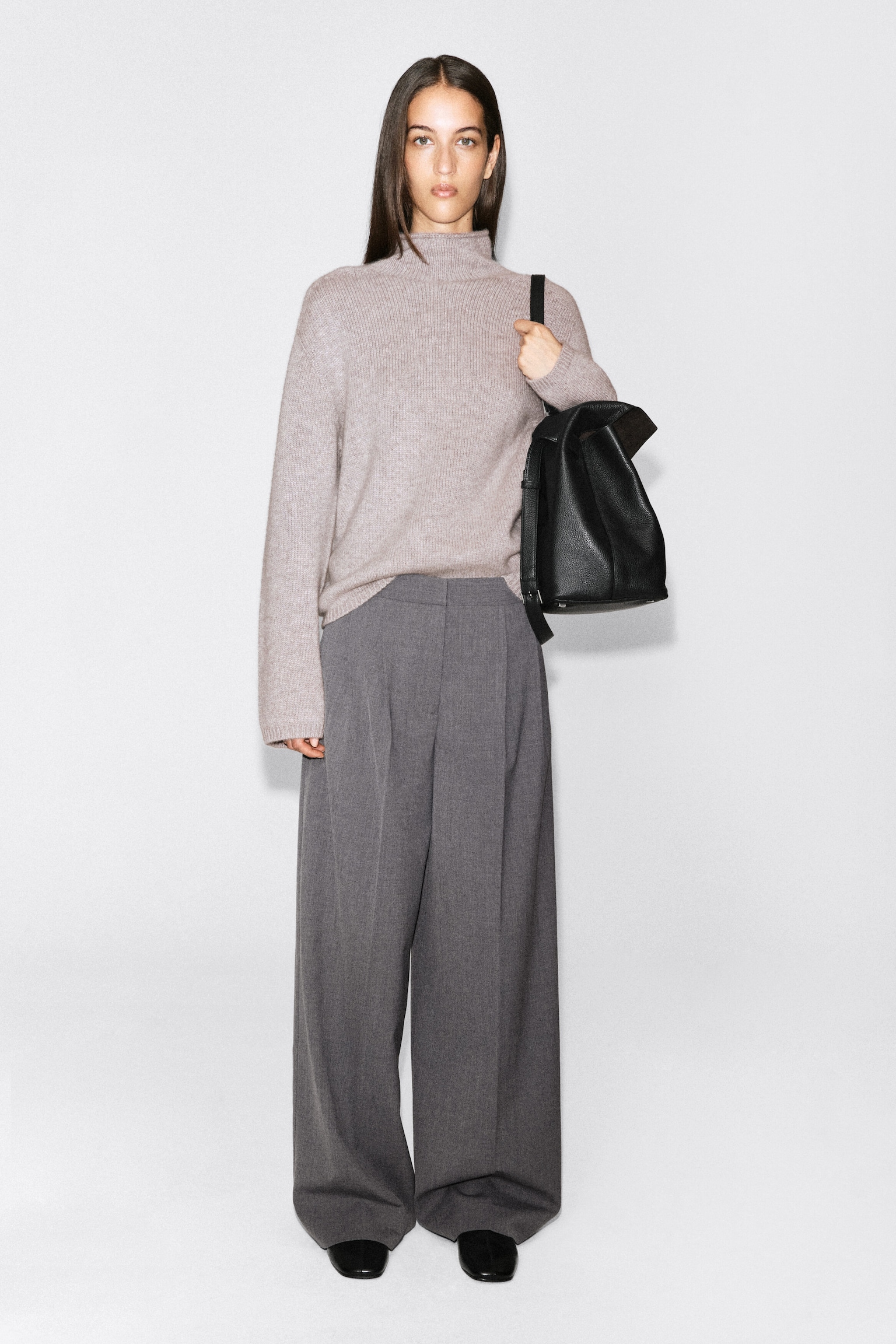 Taupe turtleneck sweater with grey wide-leg wool trousers and black loafers