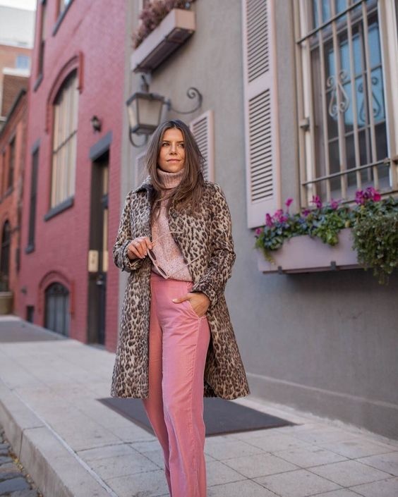 Long leopard coat worn with a pink knit sweater and pink corduroy trousers