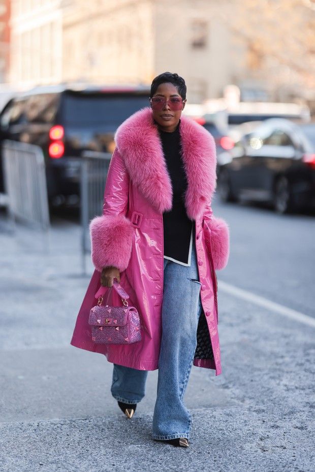 Woman in a hot pink fur-trimmed coat and wide-leg jeans, winter street style