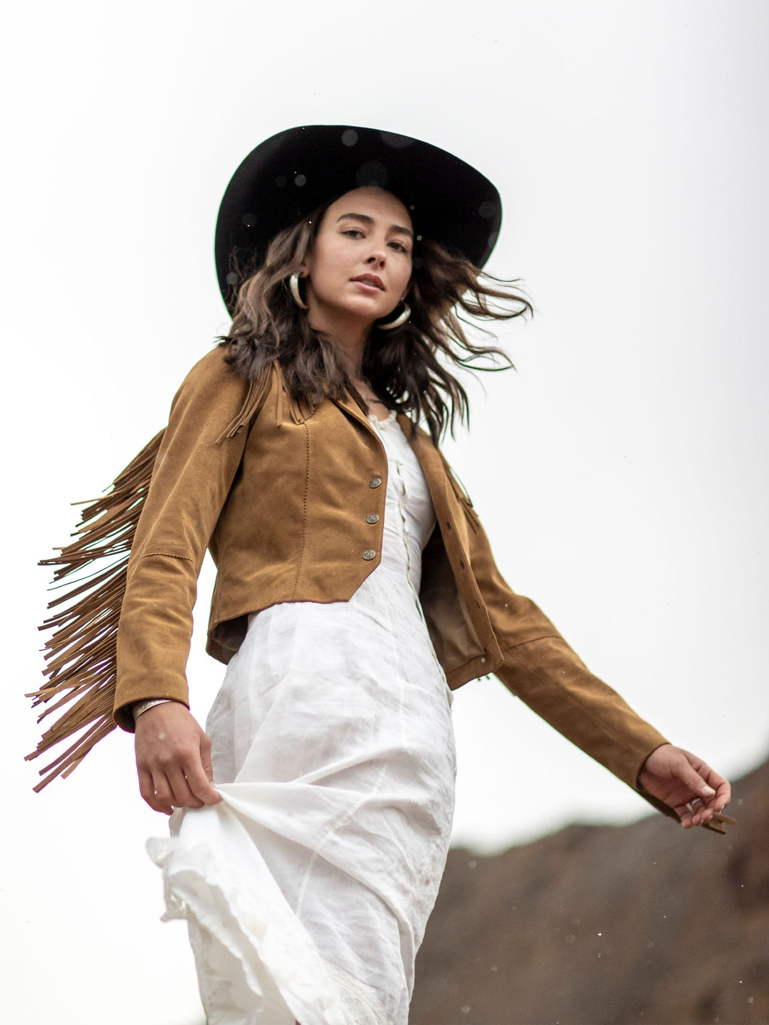 Woman wearing a suede fringe jacket in a western lifestyle setting