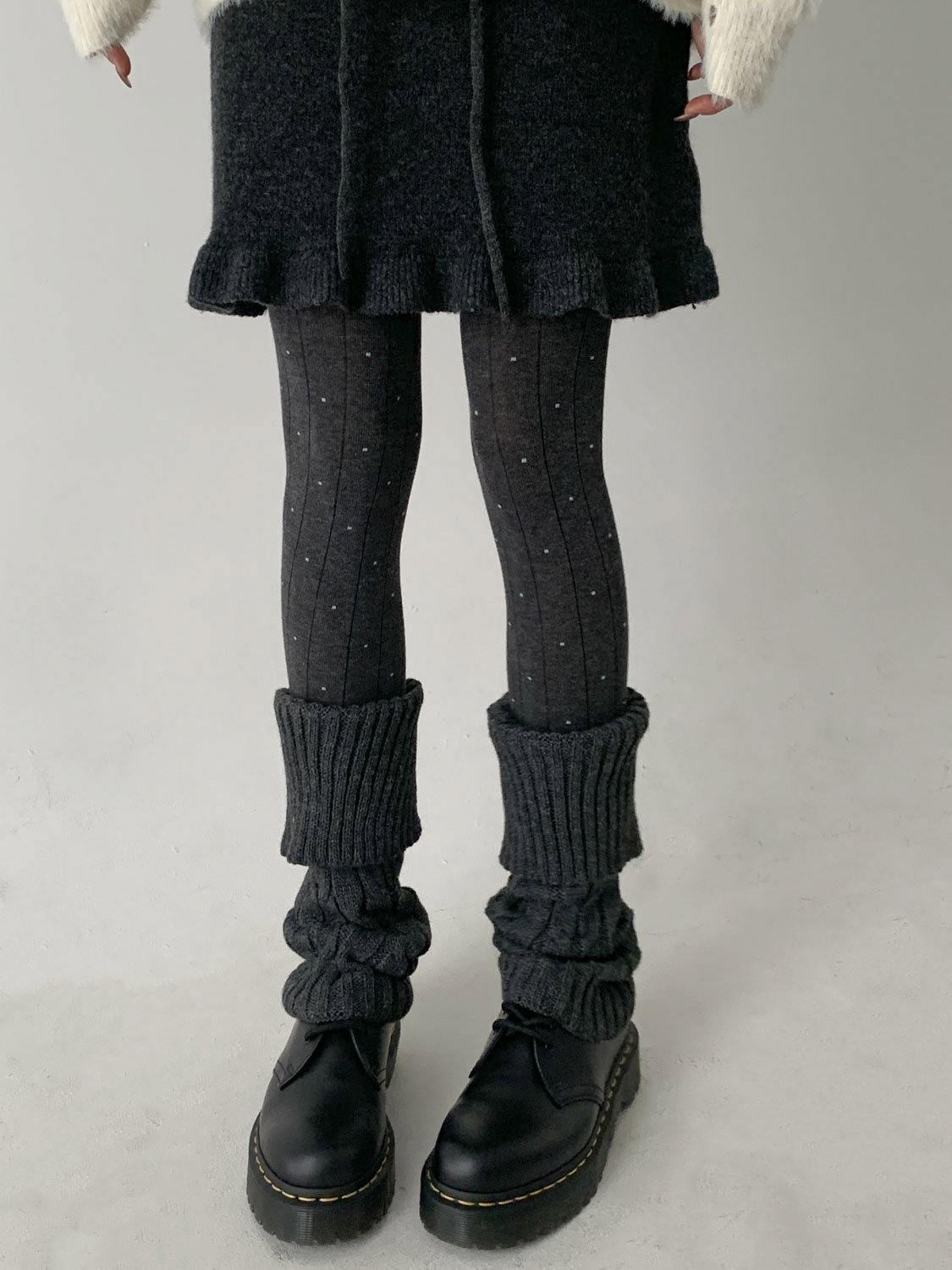 Cream leg warmers with a grey fair isle yoke band worn with tan suede booties and a black mini skirt