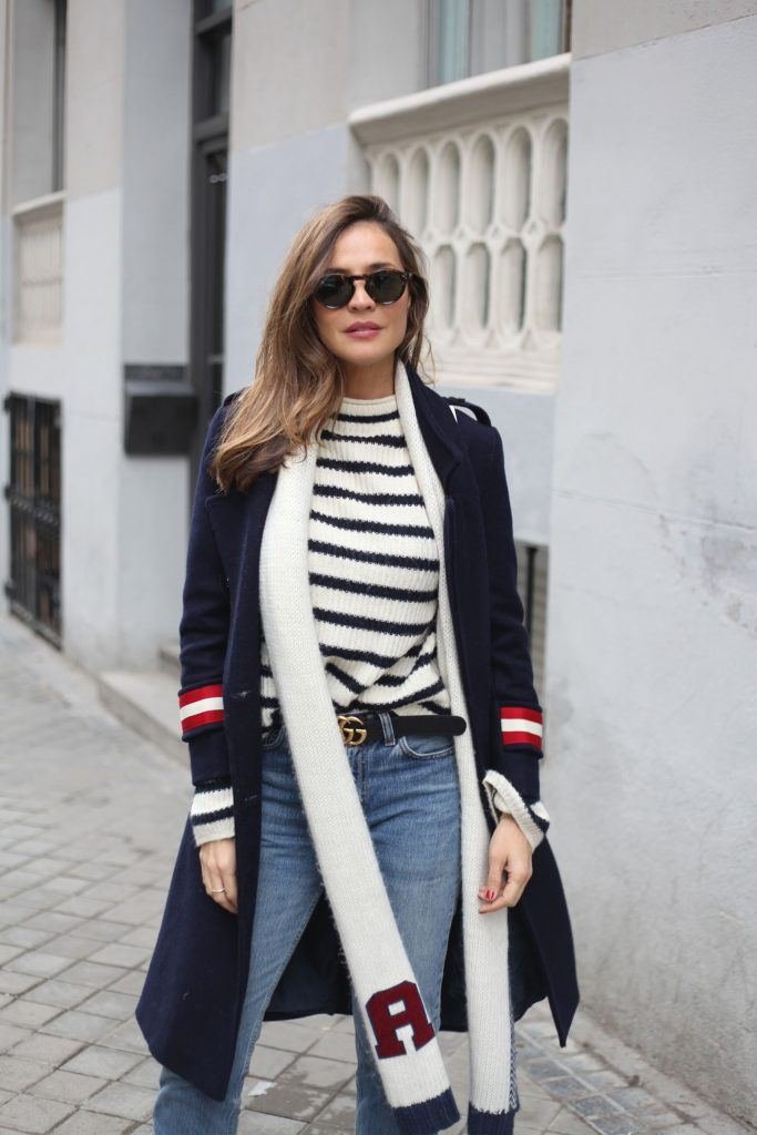 Navy wool coat with a striped sweater and jeans