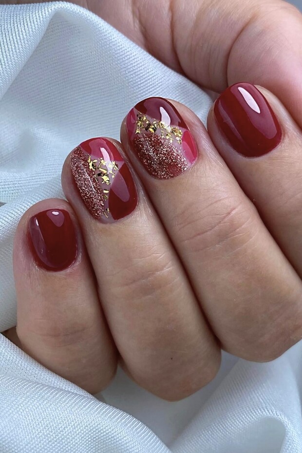 Short wine red nails with a gold glitter accent nail
