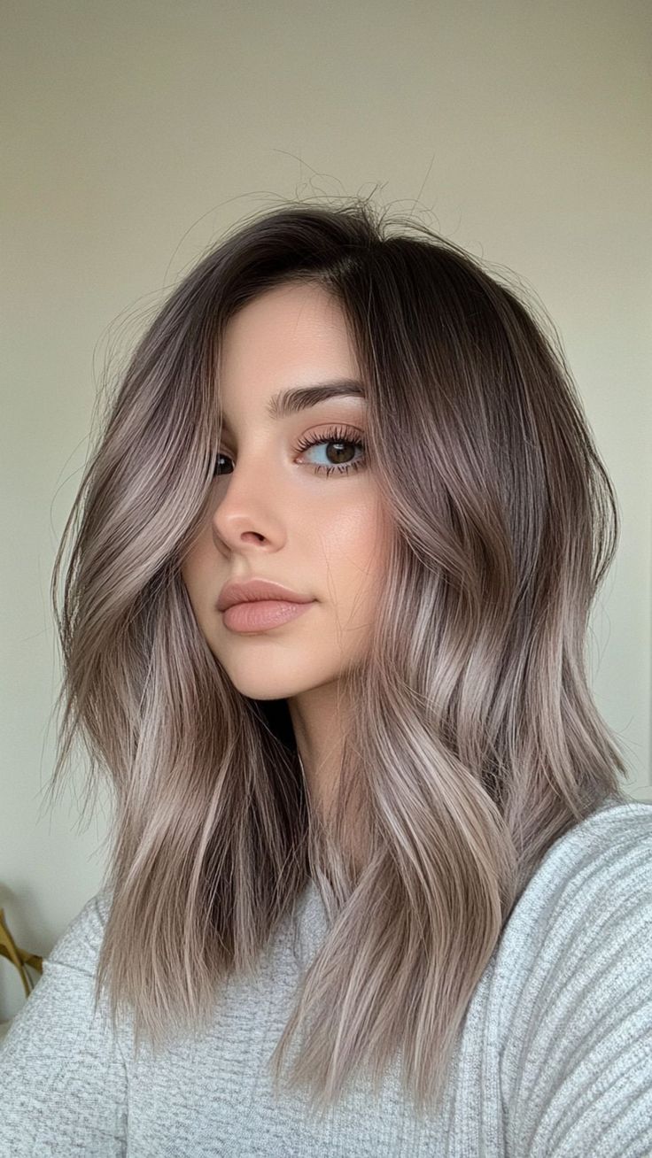 Woman with subtle ash blonde face-framing highlights on medium length hair
