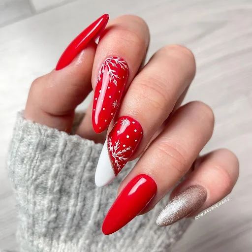 Glossy red almond nails with white snowflake line art on accent nails