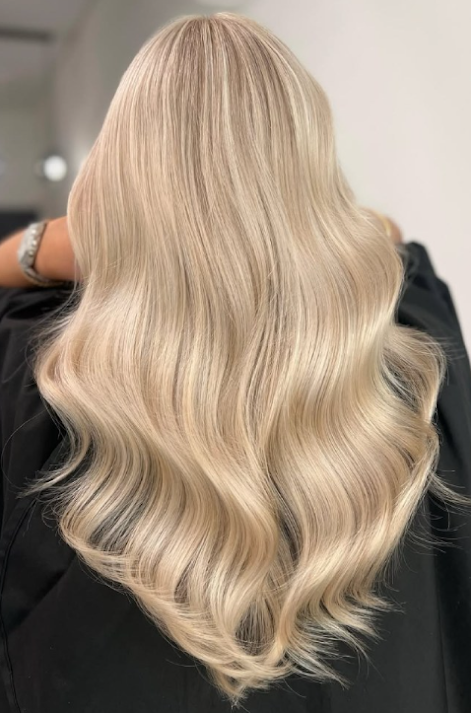 Icy platinum blonde hair worn long and straight with a glossy finish