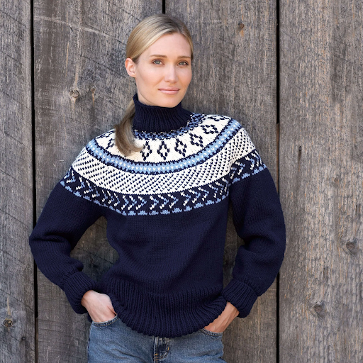 Woman wearing a navy fair-isle yoke knit sweater with medium-wash jeans