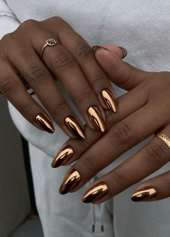 Bronze chrome metallic nails on almond-shaped nails