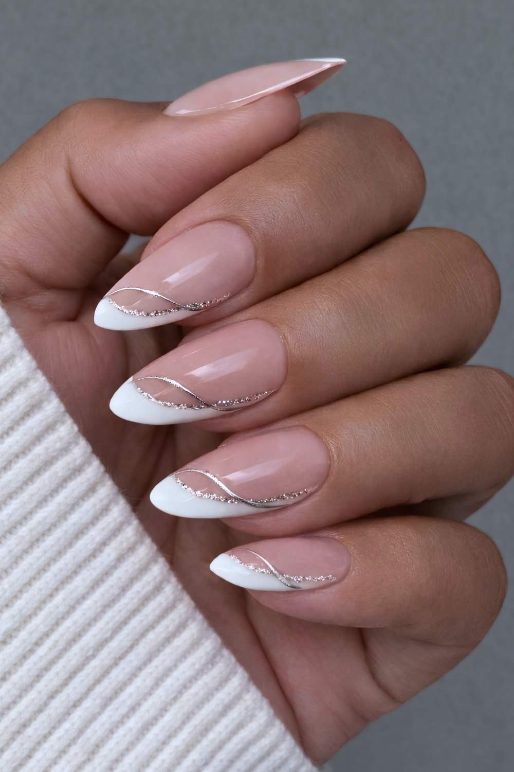 Angled white French tip winter nails with glitter accents