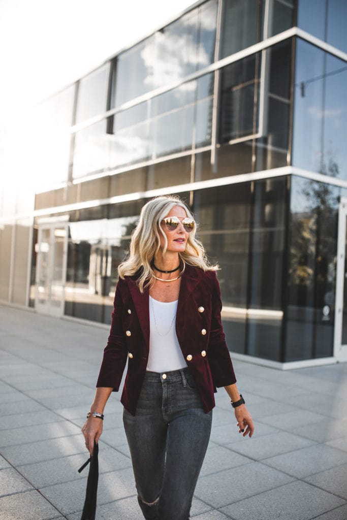 Woman wearing an aqua velvet blazer with dark denim