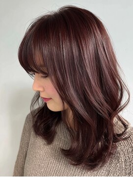 Warm mahogany medium-length hair with soft wispy bangs