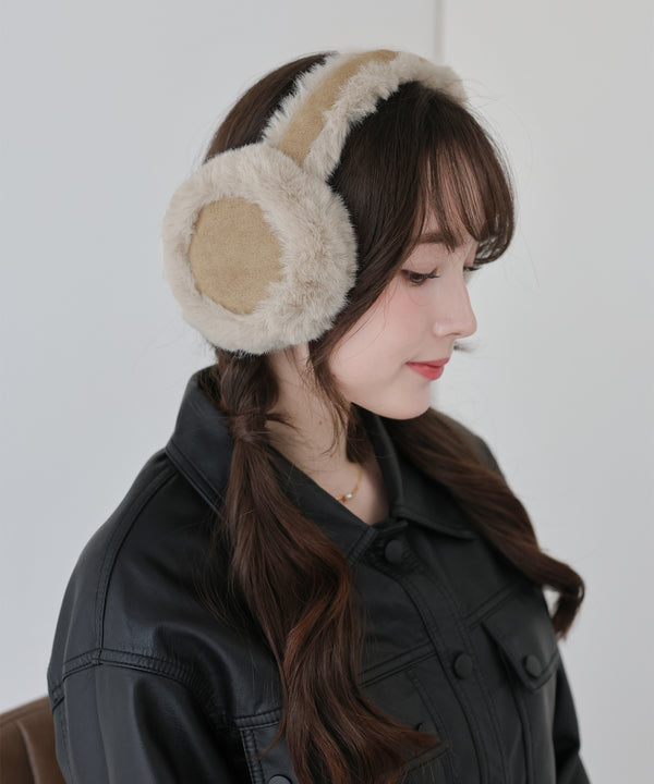 Woman wearing beige shearling earmuffs and a black leather jacket