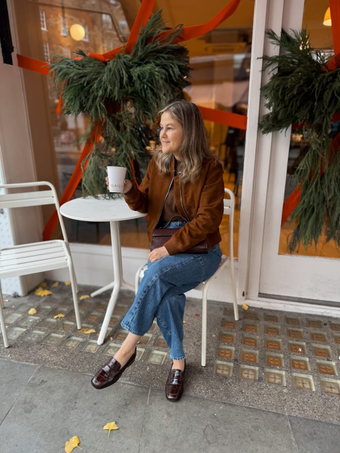 Cognac suede jacket with medium-wash barrel-leg jeans, dark top and burgundy loafers