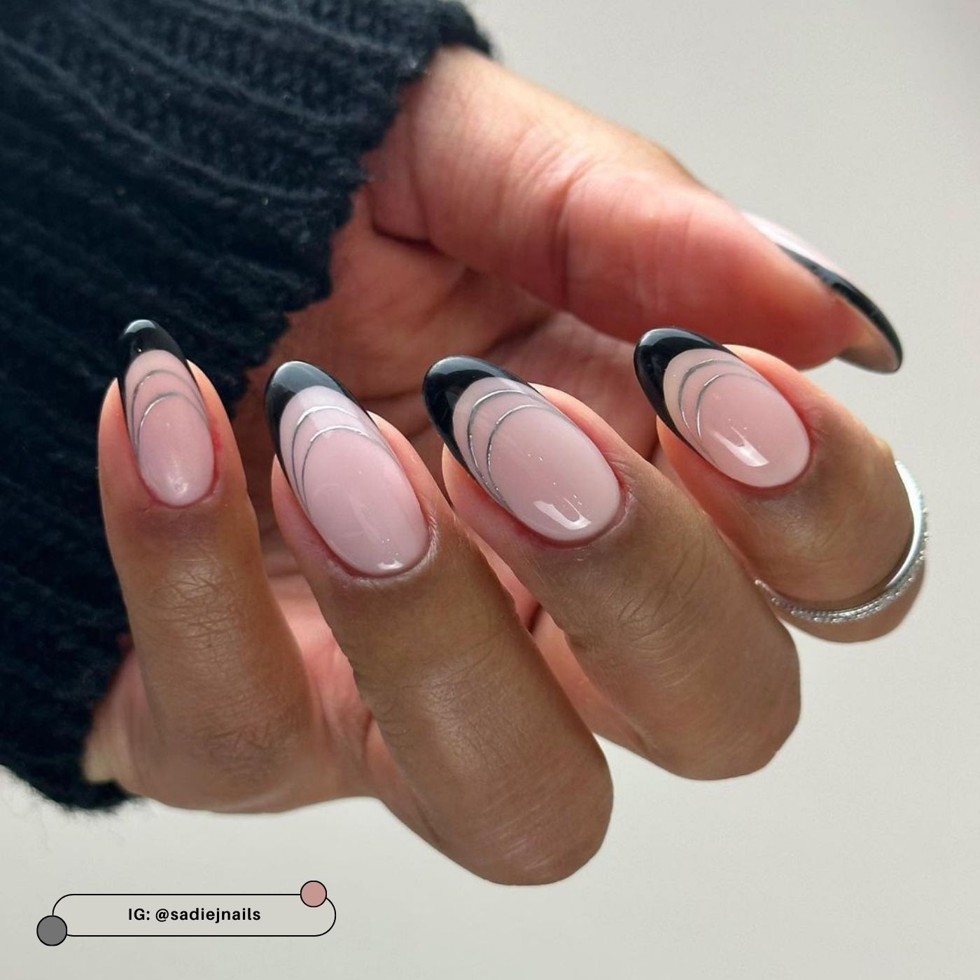 Almond nails with black French tips and thin silver lining detail