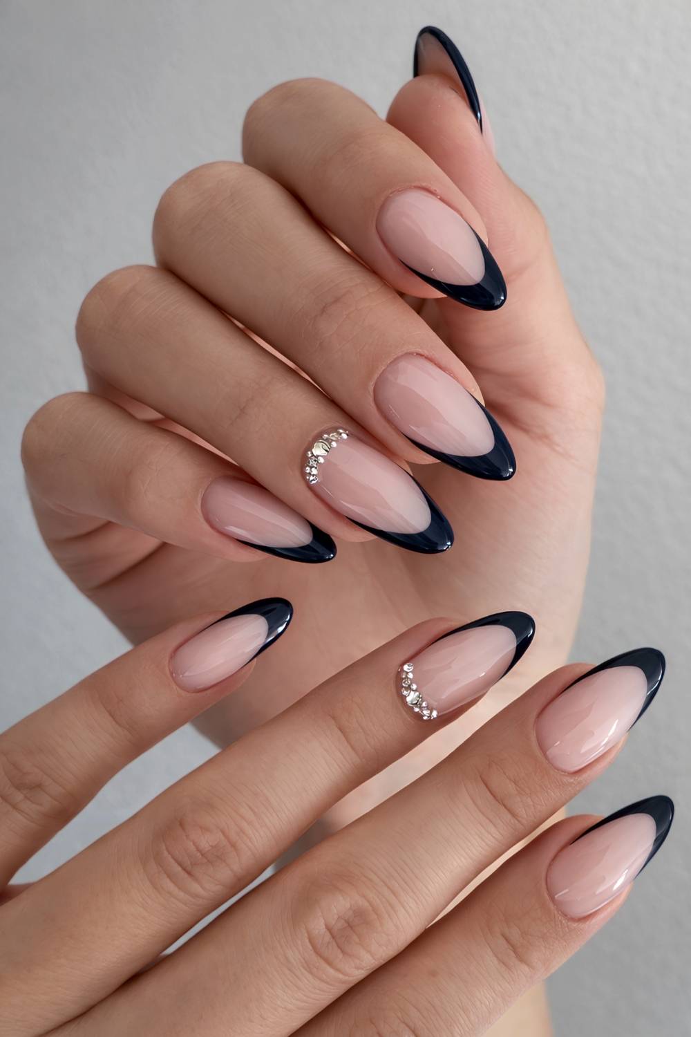 Navy French-tip nails with rhinestone crescent accents