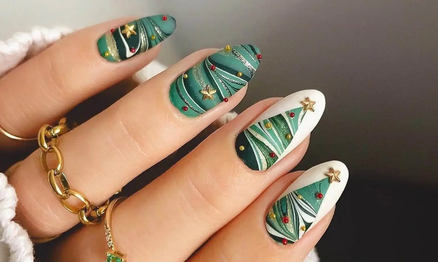 Christmas tree nail art with green swirls and gold stars