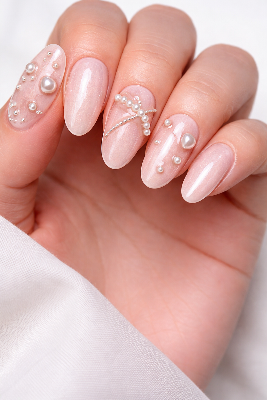 Blush pink nails with 3D pearl and bead embellishments