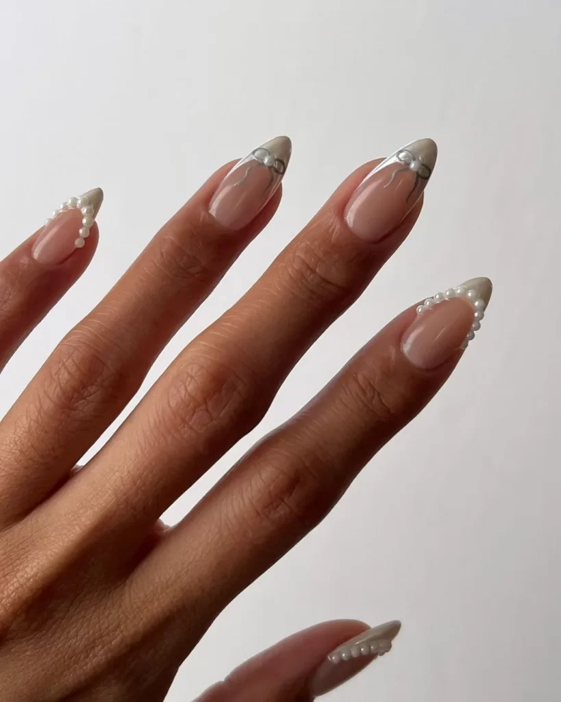 Pearl white nails with tiny decorative bow nail art