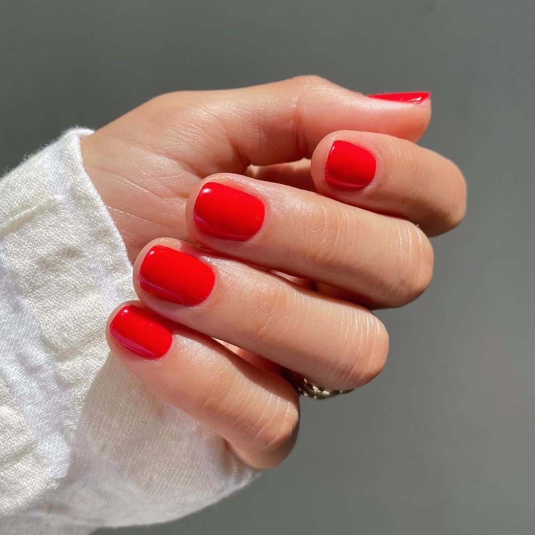 Classic red creme nail polish on short squoval nails