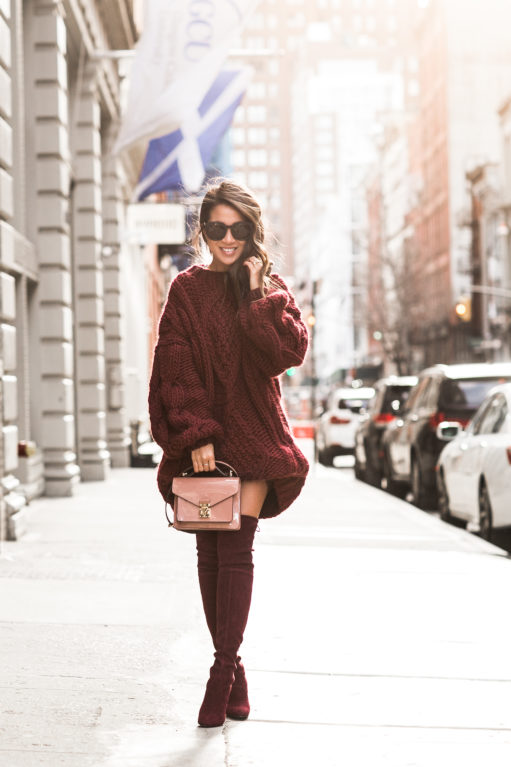 Woman wearing a burgundy chunky-knit sweater with matching burgundy boots
