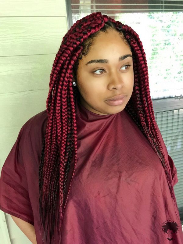 Long burgundy box braids on a Black woman in a winter outfit