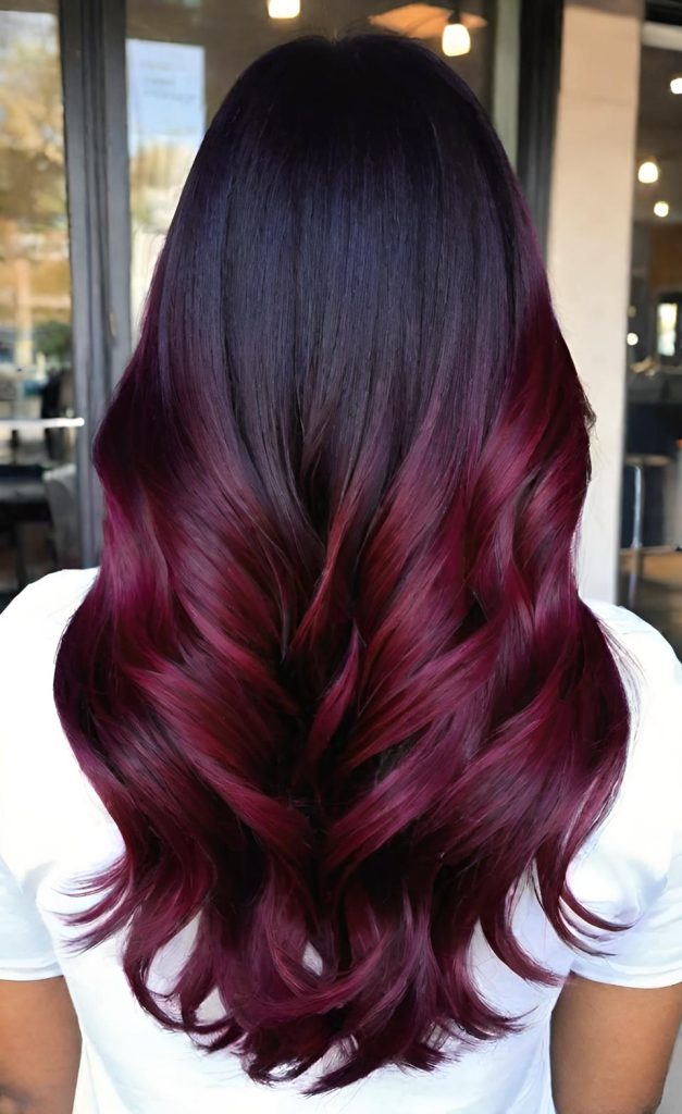 Long burgundy wine-red hair with dark roots fading to red ends