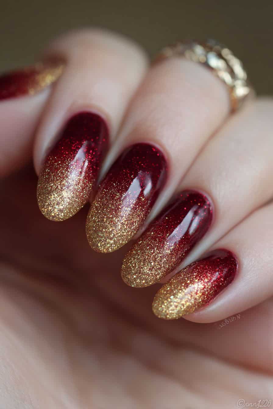 Oval nails with deep red shimmer fading into dense gold glitter at the tips