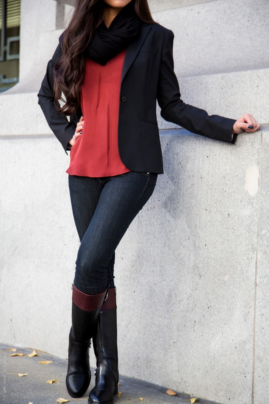 woman in black blazer, rust blouse, dark skinny jeans and black riding boots