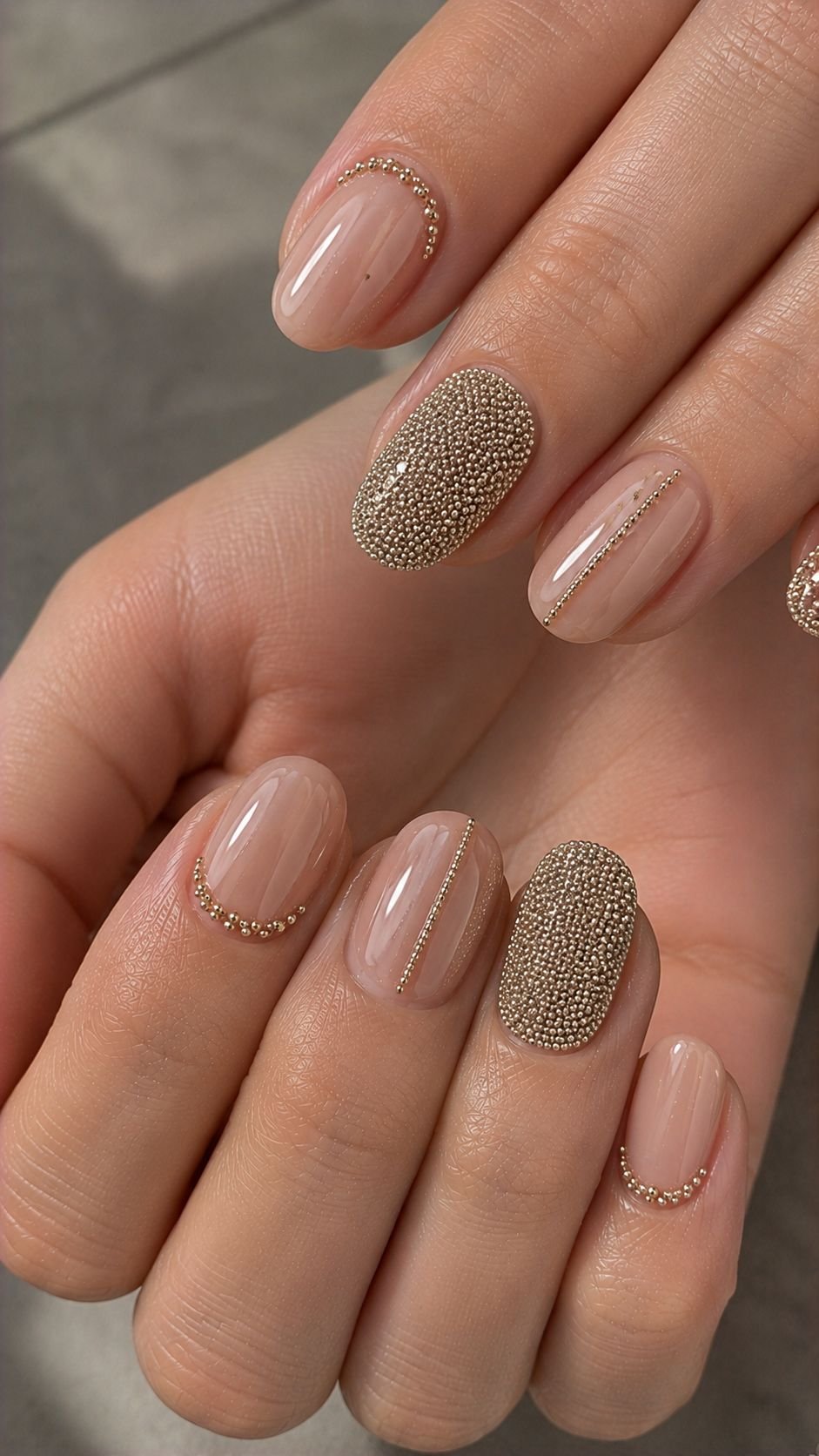 Oval nude nails decorated with gold caviar bead accents