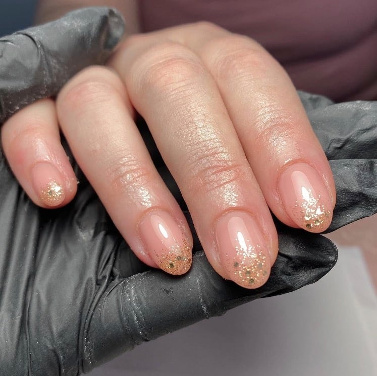 Nude nails with champagne gold glitter accent nails