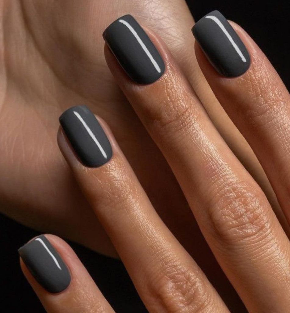 Short nails in charcoal grey with a high-gloss finish