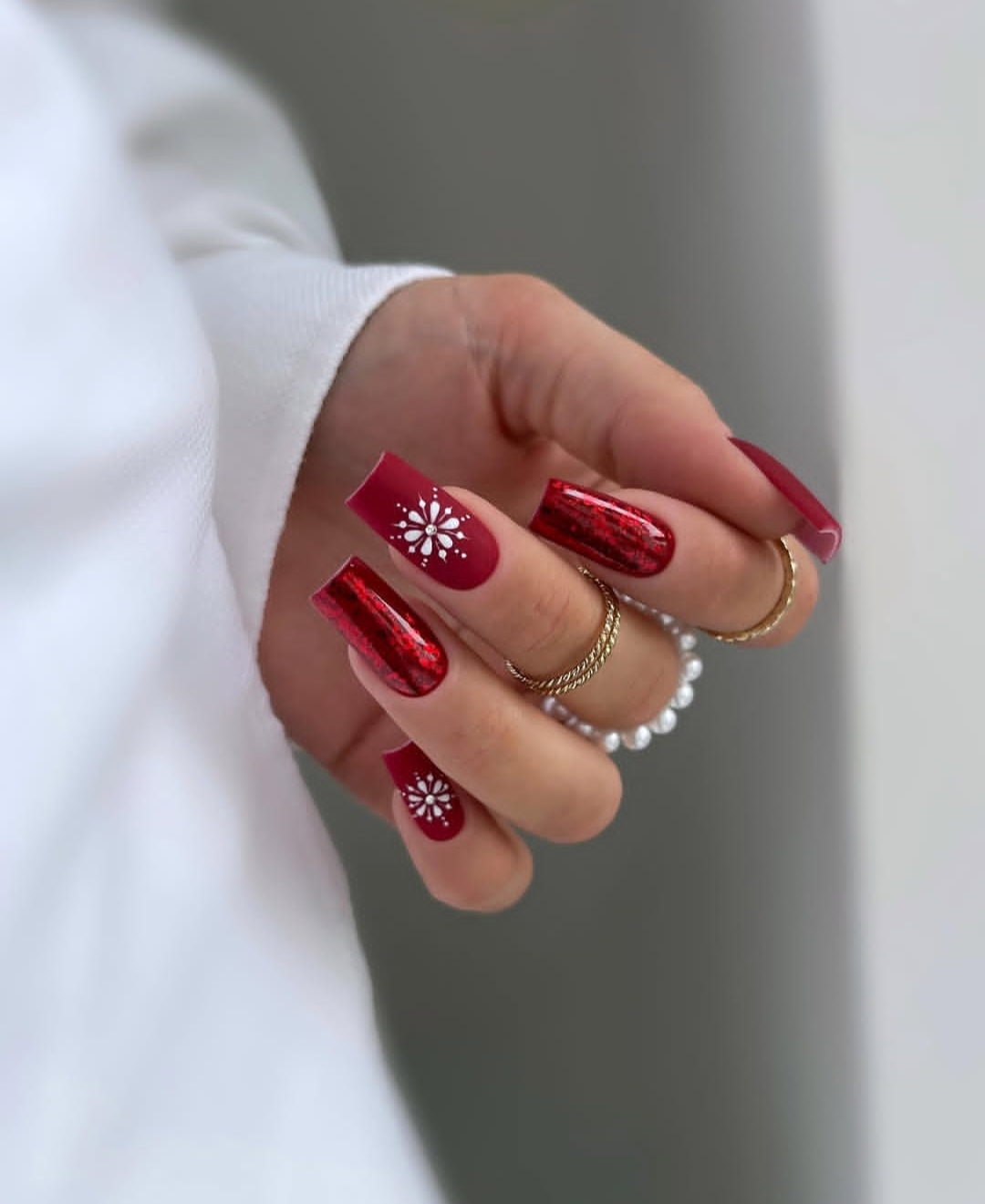 Cranberry red nails with silver-white snowflake nail art