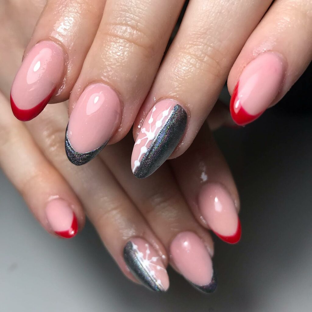 Nude almond nails with cherry red French tips, silver chrome glitter French tips and a snowflake accent