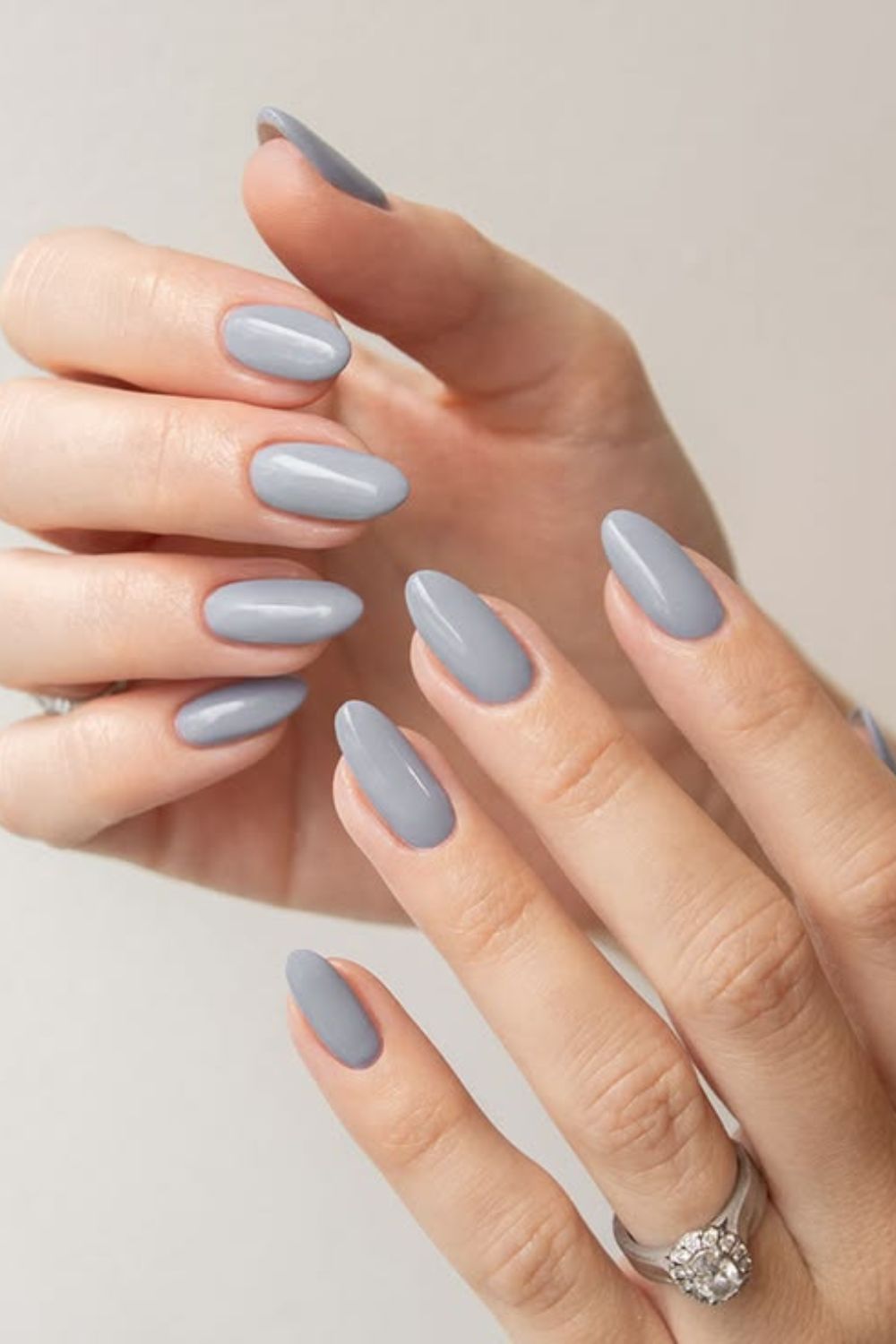 Almond-shaped nails in solid glossy pale icy blue-gray polish.