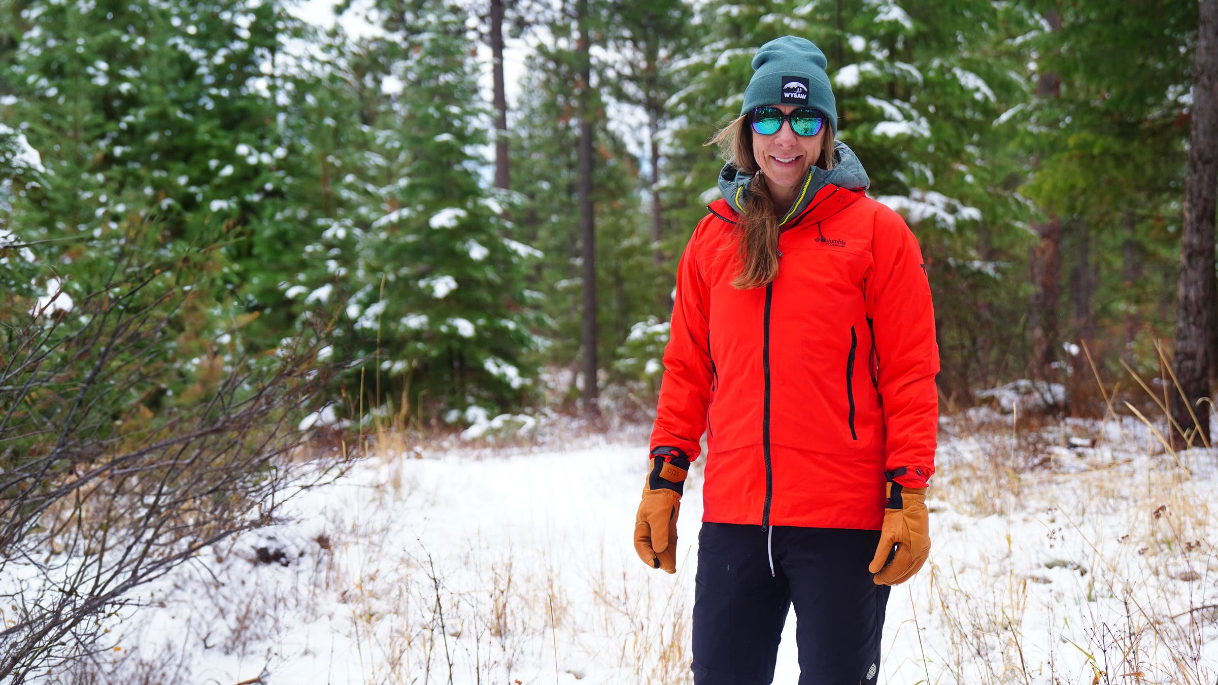 Woman wearing a hardshell rain jacket while hiking in wet weather