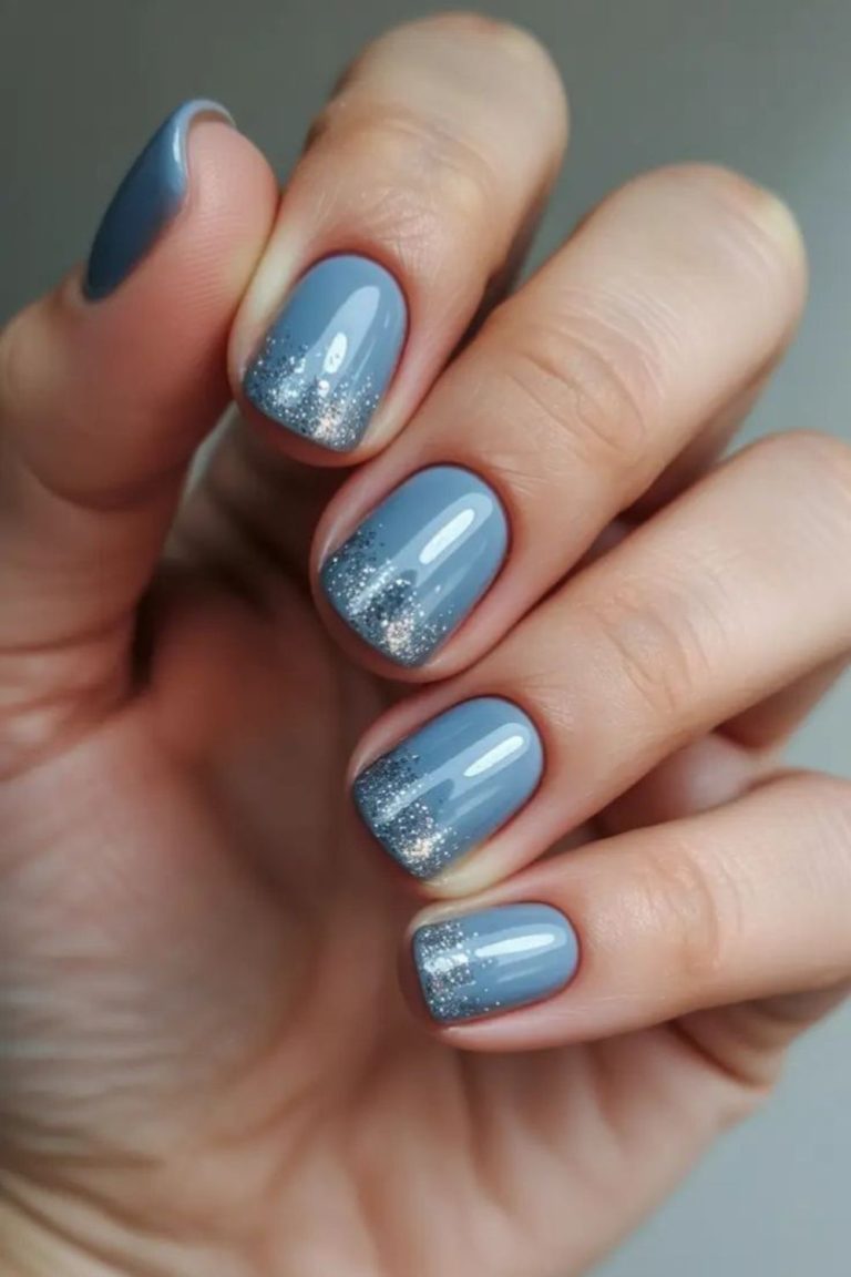 Short nails in pale ice blue with a silver glitter gradient at the tips