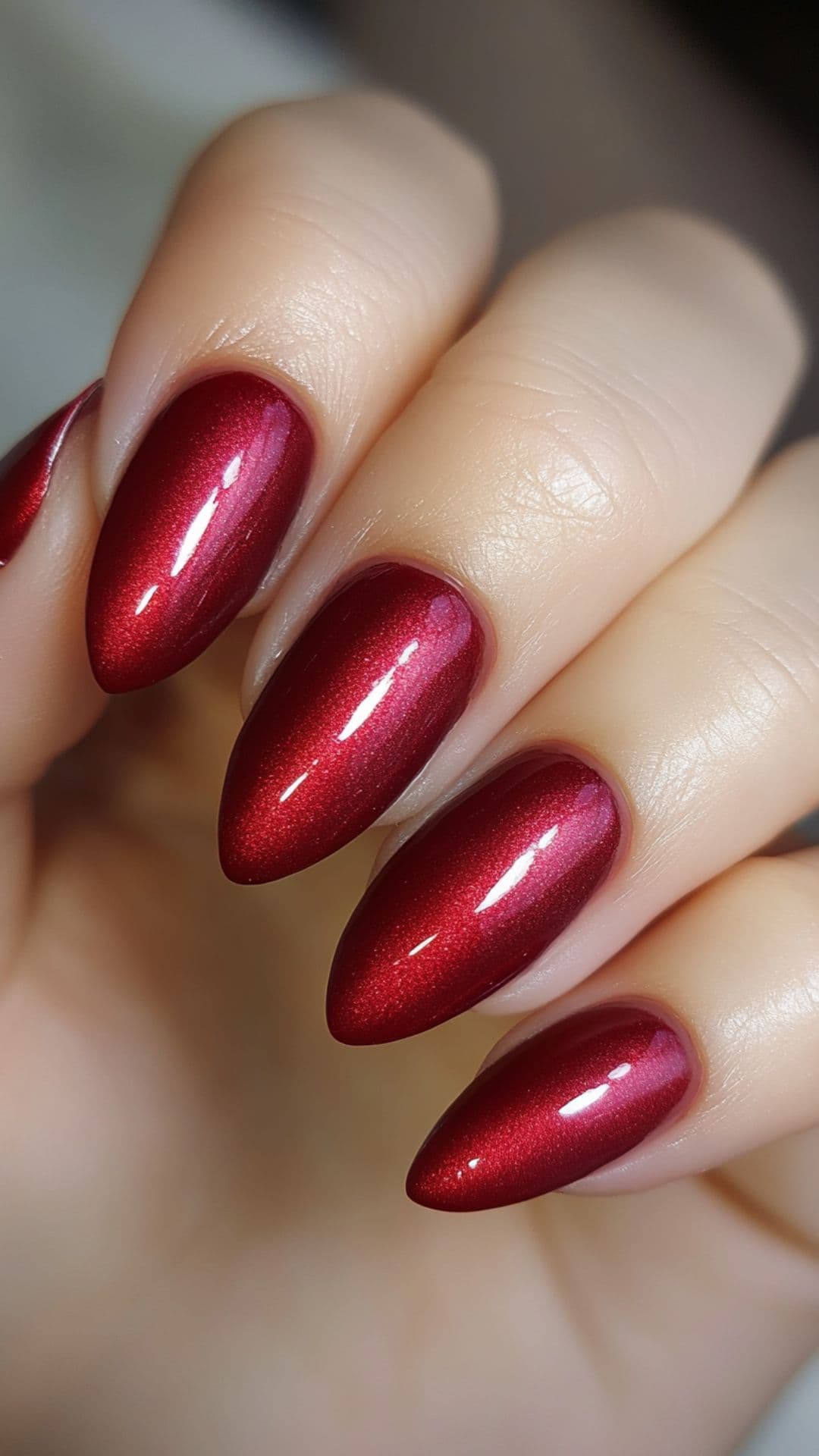 Classic crimson red almond acrylic nails with a velvet shimmer finish