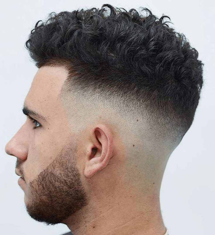Man with a curly high-top fade and tapered sides