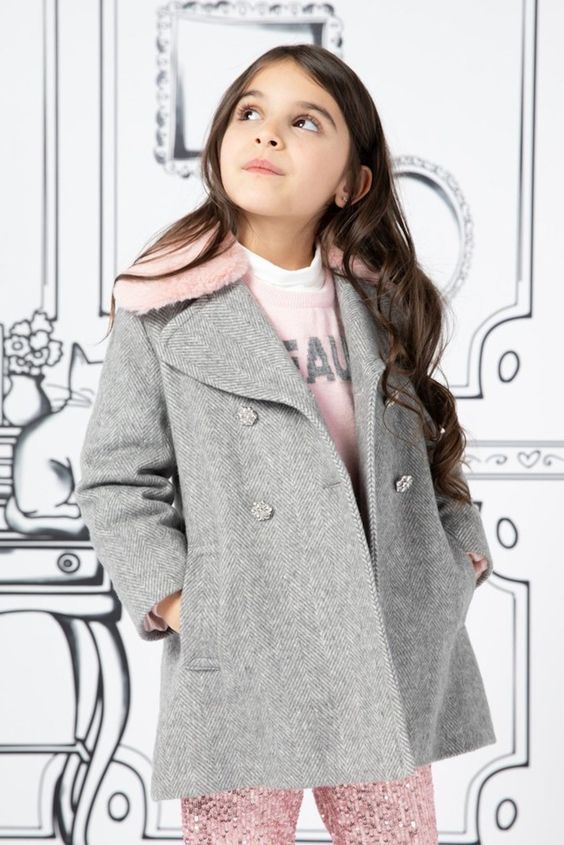 A girl wearing a longline wool coat with a sweater and leggings in winter