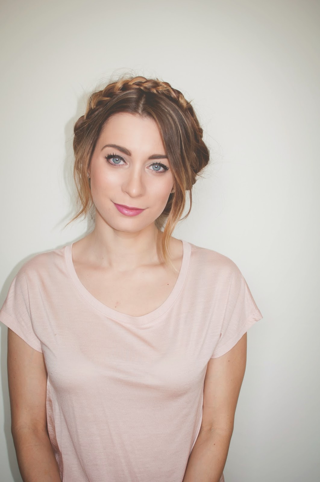 Clean front-facing photo of finished double milkmaid braids wrapped into a crown, ash-brown hair with highlights.